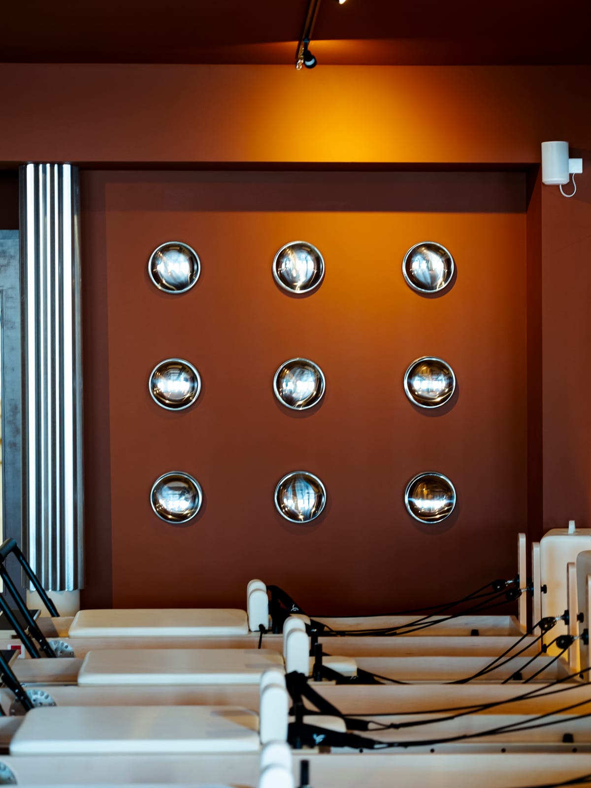 Mur de hublots chromés et machines Reformer dans la salle principale Bonnie Eight